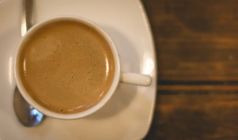 Taza de café recién servido sobre la mesa